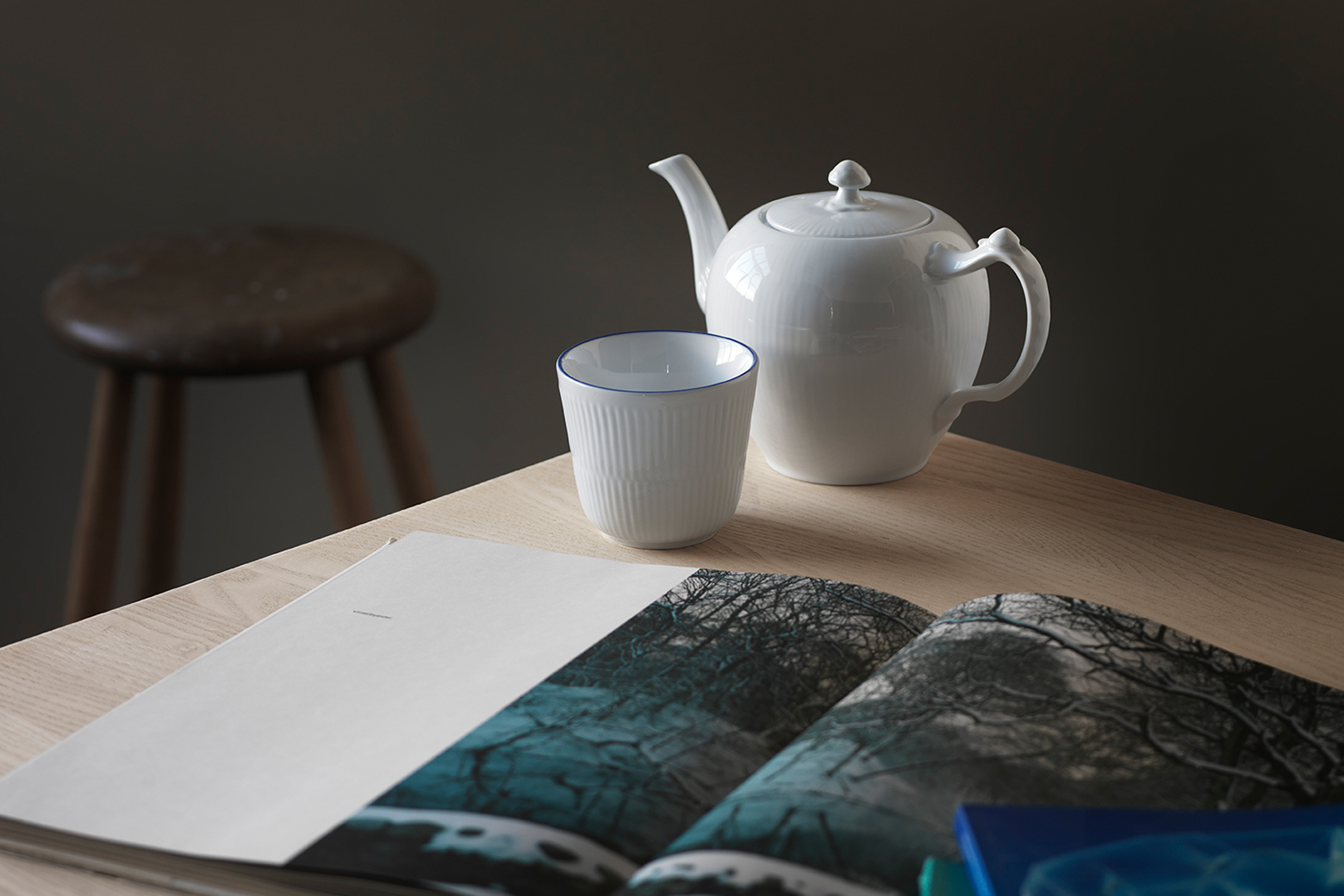 Blueline Thermal mug on a coffee table alongside the white fluted teapot